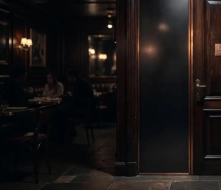 Entrée discrète du club privé Comptoir Brume, éclairage tamisé et boiseries sombres.