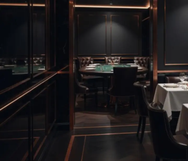 Salon privé du Comptoir Brume avec lumières cuivrées, tables dressées et ambiance de poker discret en arrière-plan